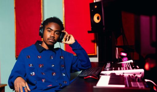 Musiikintekijä kuulokkeissa studion syntetisaattorien äärellä